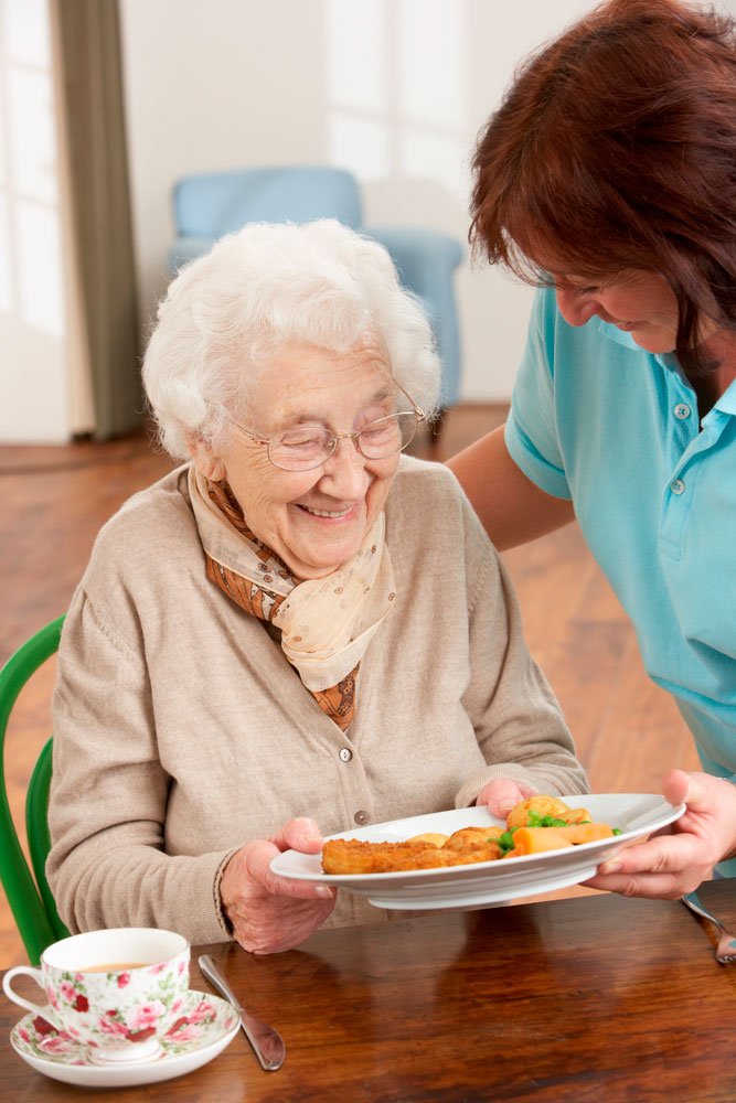 Caregiver providing medication reminders to a senior man in Aurora, CO – Golden Touch Home Care safety services.